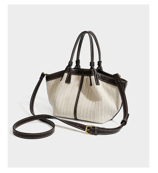 Cremefarbene geflochtene Tote-Bag mit dunkelbraunen Besätzen in Lederoptik, kontrastierenden weißen Nähten, zwei oberen Henkeln und abnehmbarem Schulter