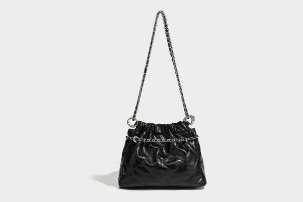 Glossy diamond-quilted drawstring bucket bag with silver chain shoulder strap and medallion charm, detail view 30