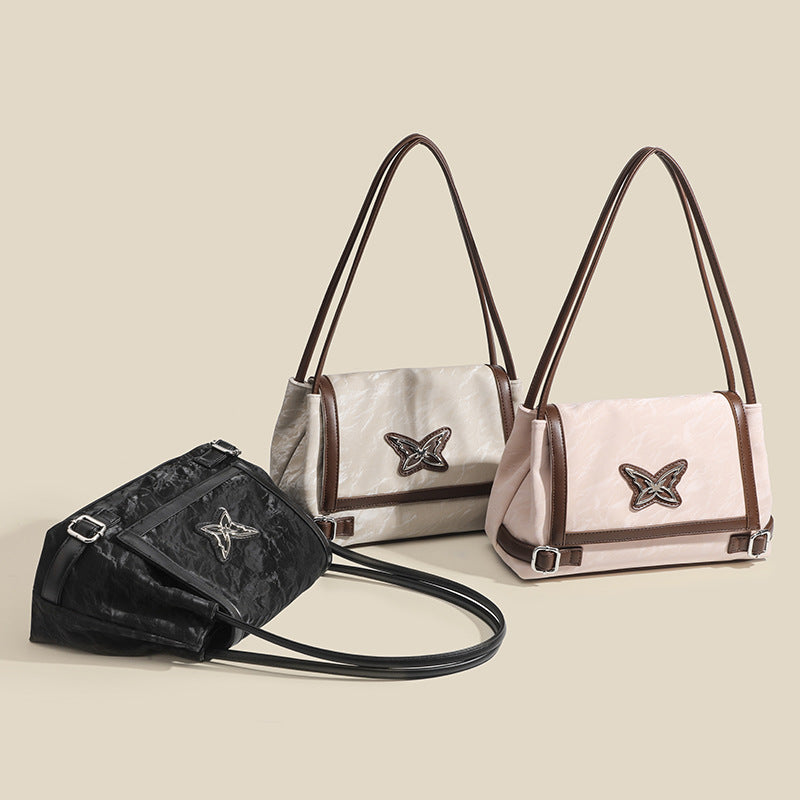 Structured crinkle-finish flap shoulder bag with butterfly metal appliqué and dark brown contrast trim, detail view 2