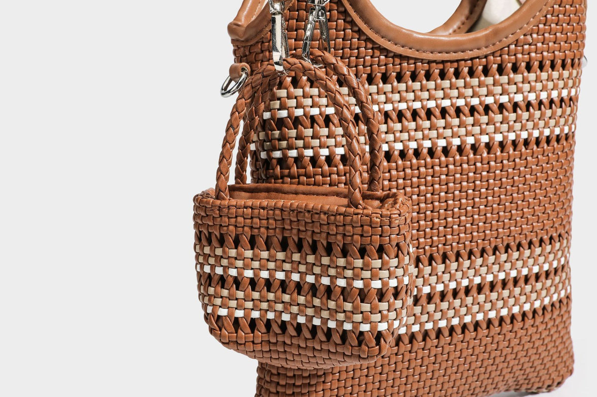 Color-block woven tote bag with rounded leather-look handles, detachable crossbody strap, and matching mini clip-on pouch in