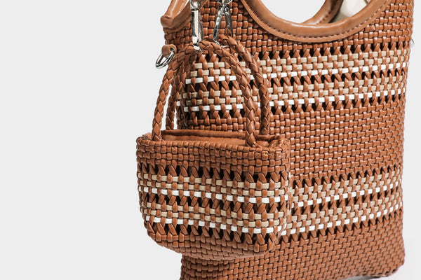 Color-block woven tote bag with rounded leather-look handles, detachable crossbody strap, and matching mini clip-on pouch in