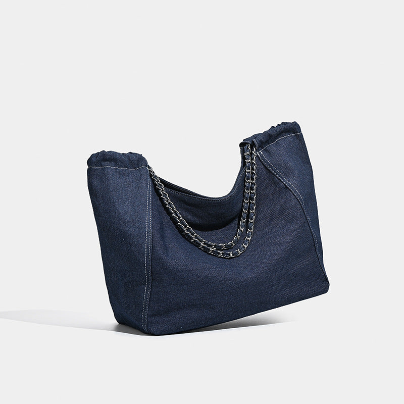 Large slouchy denim tote bag with silver-tone chain strap and contrast topstitching, detail view 3