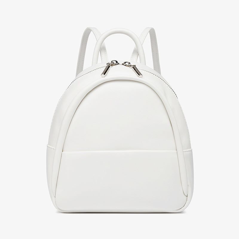 Kleine kuppelförmige Mini-Rucksackhandtasche in Pastellgelb mit glatter Oberfläche in Lederoptik, bogenförmigem Reißverschluss oben und silberfarbenen Details