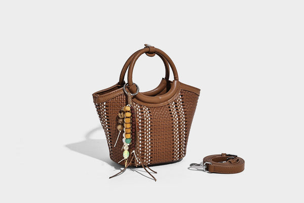 Kleine strukturierte Beuteltasche aus geflochtenem Material mit rundem Tragegriff in Lederoptik, silberfarbenen Beschlägen und perlenbesetztem Quastenanhänger, Detail