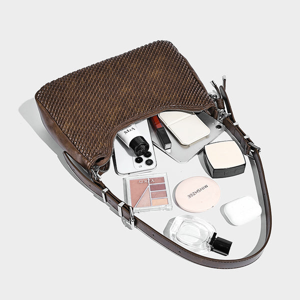 Woven crescent hobo shoulder bag with smooth side panels, zip-top closure, silver-tone charm hardware, and adjustable, detail