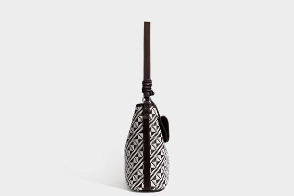 Geflochtene Schultertasche mit geometrischem Ethno-Muster, Besatz in dunkelbrauner Lederoptik, langem verstellbarem Träger und kleinem hängendem Reißverschluss