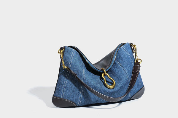 Slouchy denim shoulder bag with dark leather-look trim, gold-tone chain-link hardware, and top zipper closure, detail view 32