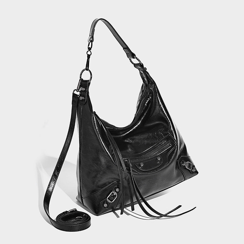 Large glossy crinkled hobo shoulder bag with dark metal studs, zip closure, front zip pocket, and adjustable crossbody strap