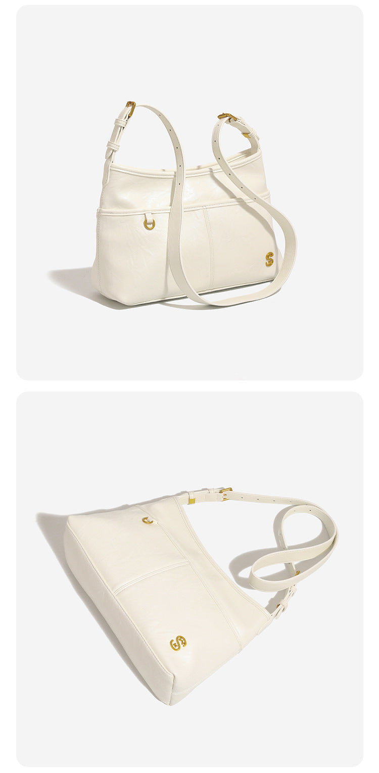Relaxed leather-look shoulder tote bag in cream white with front exterior pocket, gold-tone ring hardware, and adjustable