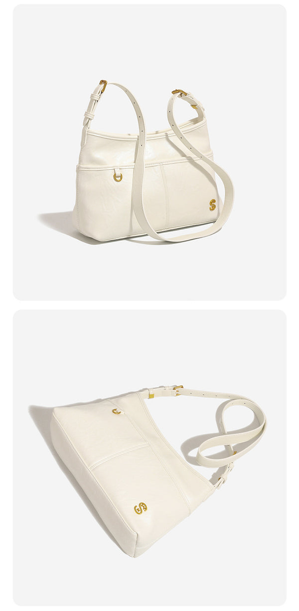 Relaxed leather-look shoulder tote bag in cream white with front exterior pocket, gold-tone ring hardware, and adjustable