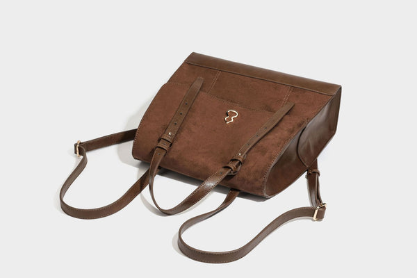 Structured suede-look convertible backpack handbag with flap closure and gold-tone emblem hardware in chocolate brown, detail