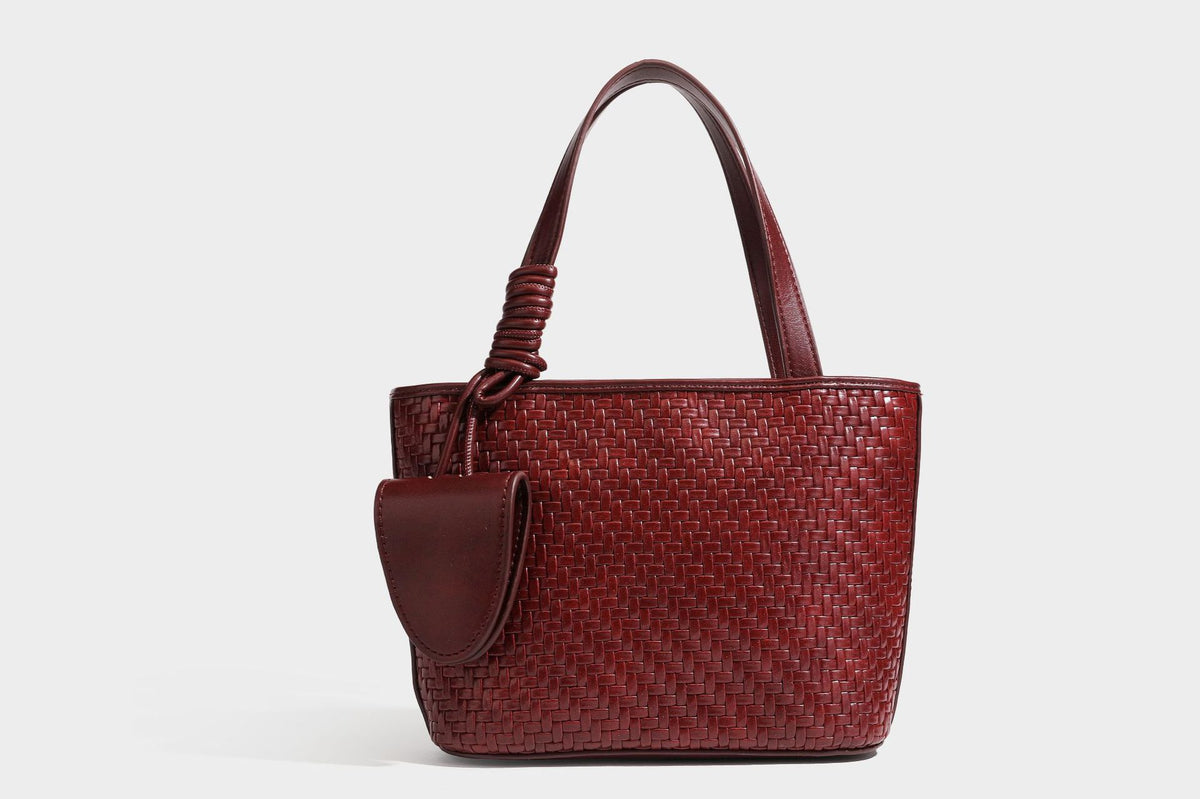 Strukturierte Tote Bag mit gewebter Oberfläche in Braun, goldfarbenen Metalldetails, seilumwickelten Tragegriffen, einer kleinen Fronttasche und weiteren Details