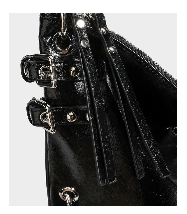 Black glossy leather-look slouchy shoulder bag with silver stud and eyelet hardware, top zip closure, front zip pocket, and