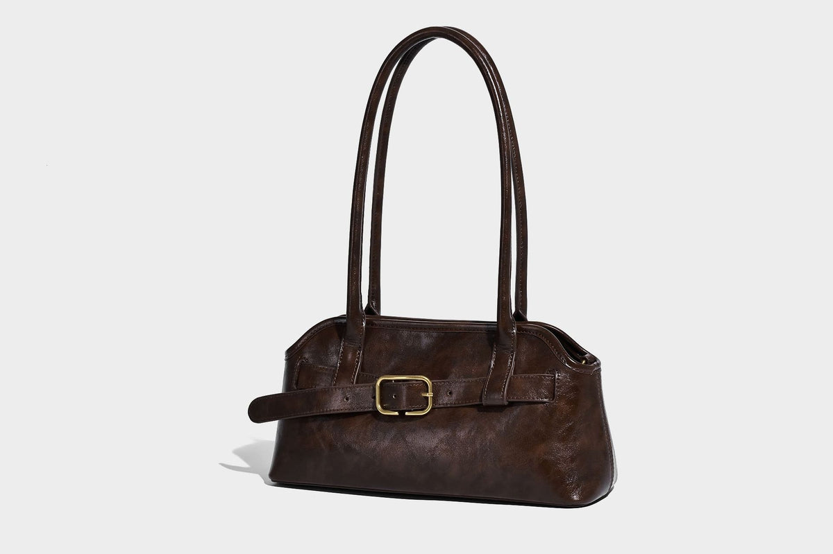 Strukturierte dunkelbraune Henkeltasche mit Öl-Wachs-Finish, vorderer Gürtelschnalle, goldfarbenen Beschlägen und zwei Tragegriffen, Detailansicht