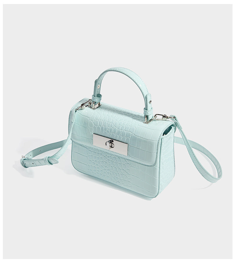 Small structured rectangular satchel with glossy crocodile-embossed finish, arched top handle, front flap, and silver-tone