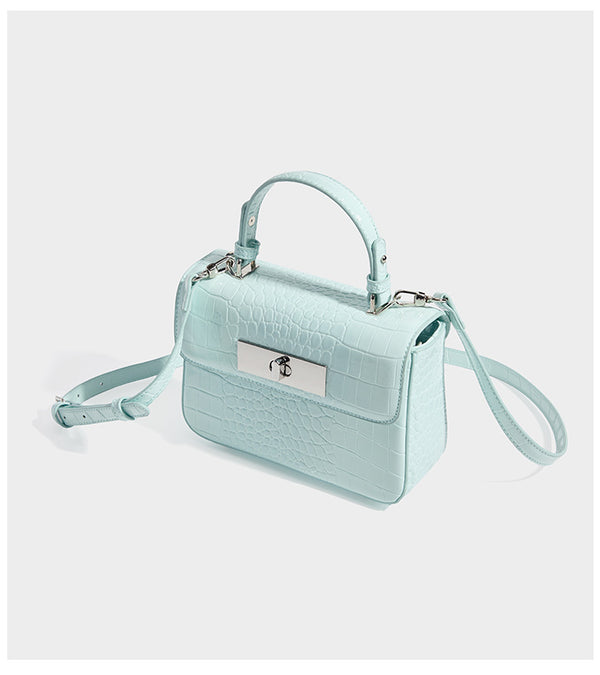 Small structured rectangular satchel with glossy crocodile-embossed finish, arched top handle, front flap, and silver-tone