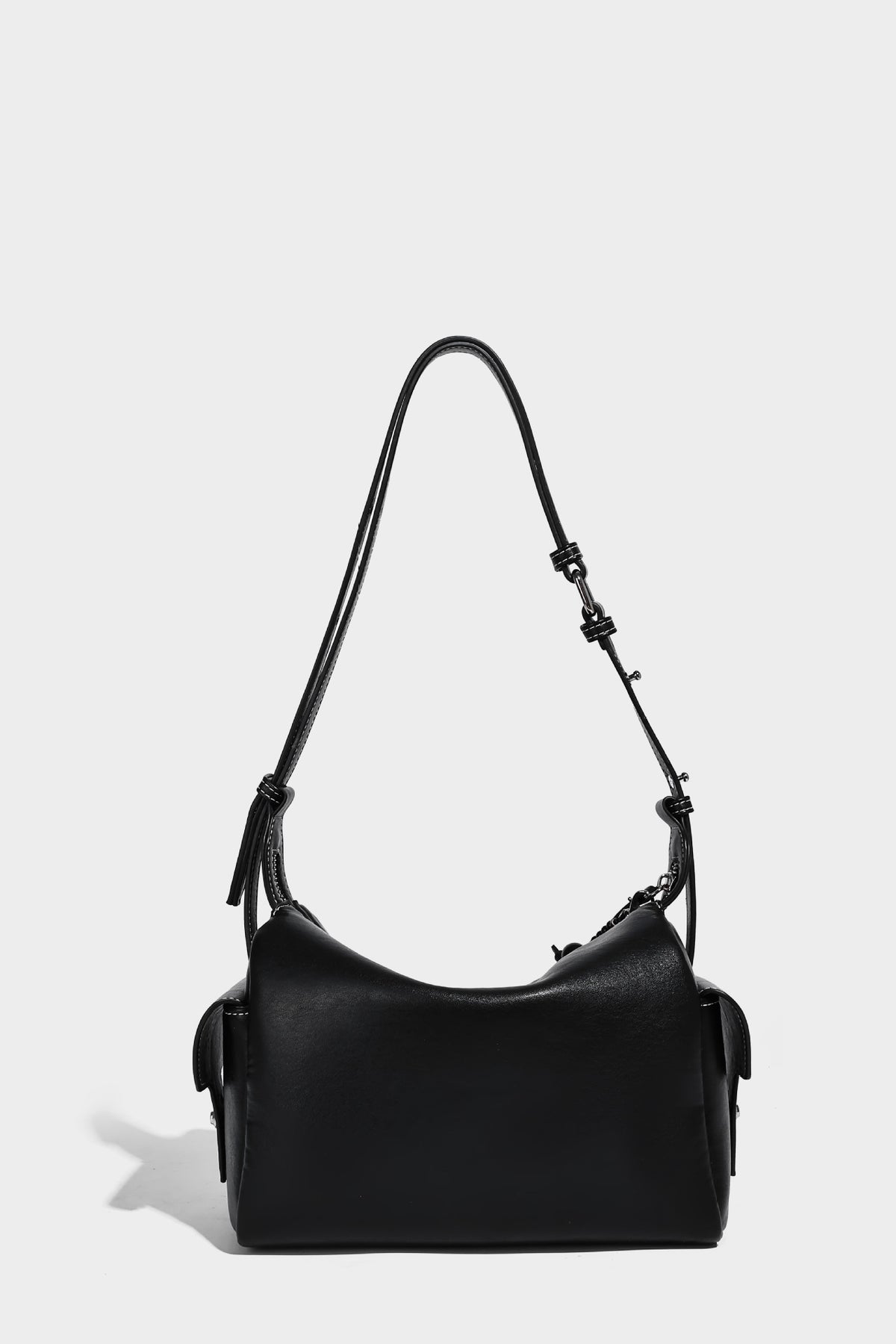 Small slouchy moto-style crossbody bag in smooth matte leather-look finish with white contrast stitching, silver-tone, detail