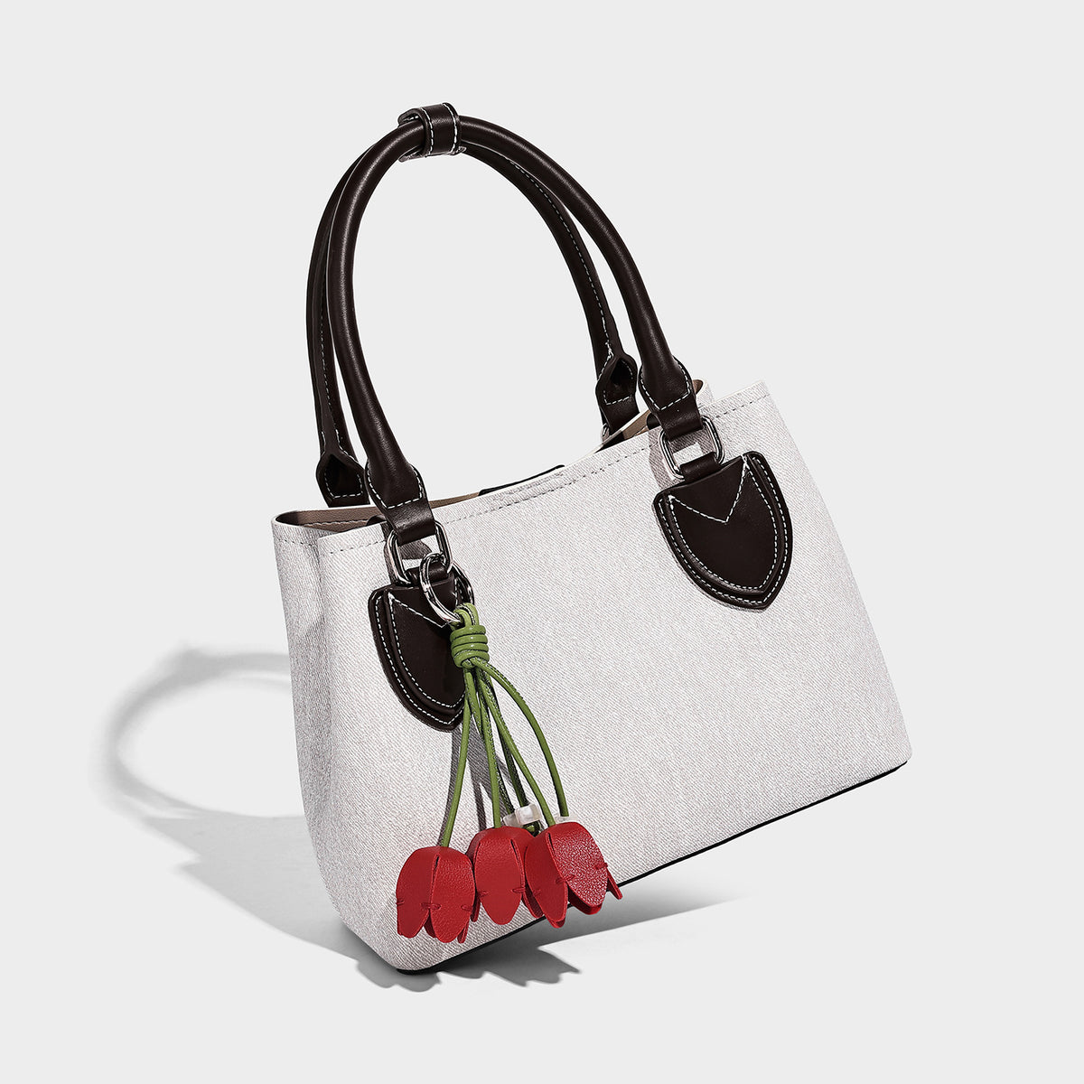 Structured light-blue denim-look tote bag with black leather-look handles, white contrast stitching, silver-tone hardware