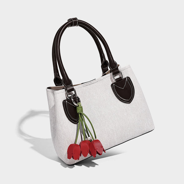 Structured light-blue denim-look tote bag with black leather-look handles, white contrast stitching, silver-tone hardware