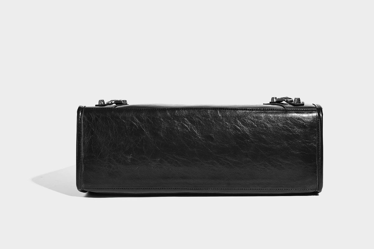 Large structured leather-look tote bag with front zip pocket, moto hardware accents, and long double shoulder straps, detail