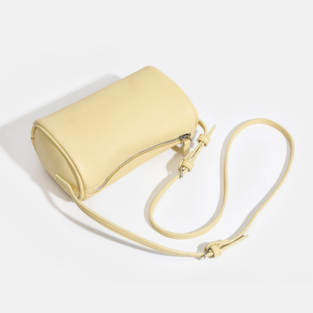 Kompakte Schultertasche in Lederoptik mit genarbter Struktur, Reißverschluss oben, geknotetem Tragegriff und verstellbarem Crossbody-Riemen, Detailansicht