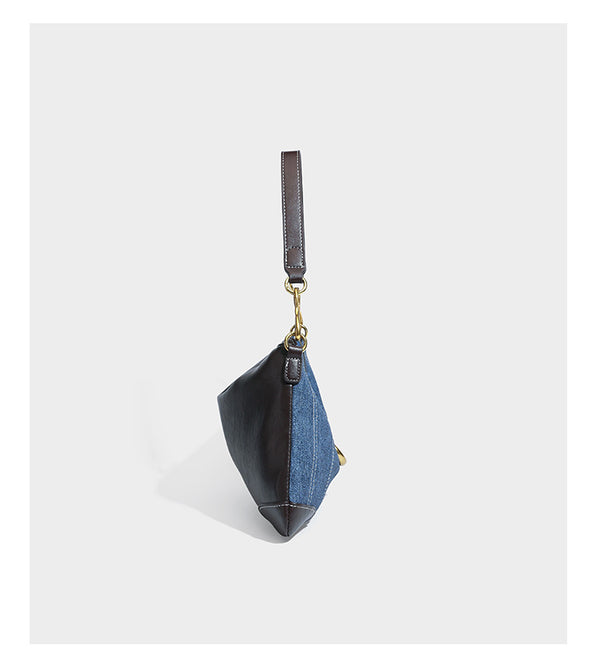 Slouchy denim shoulder bag with dark leather-look trim, gold-tone chain-link hardware, and top zipper closure, detail view 9