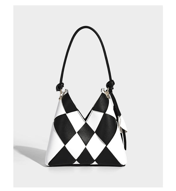 Compact bucket shoulder bag with black-and-white diamond patchwork panels, knotted top handle, gold-tone hardware, and