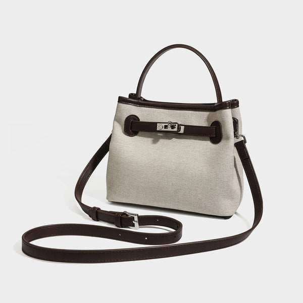 Small structured beige canvas top-handle bag with dark brown leather-look trim, silver turn-lock hardware, and detachable