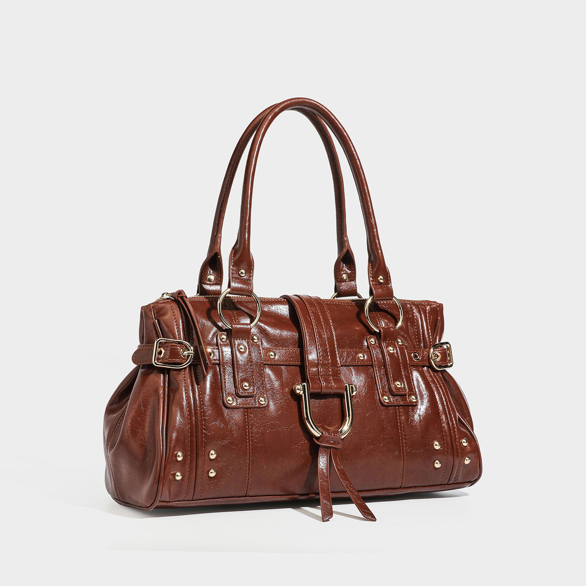Glänzende Henkeltasche in Lederoptik mit zwei Tragegriffen, goldfarbenen Nieten und Ringen, dekorativem Riemen mit Schnalle auf der Vorderseite und