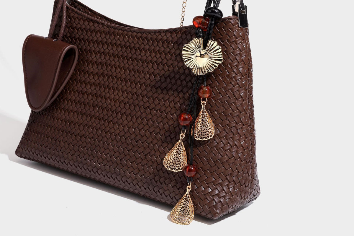 Woven-texture hobo shoulder bag in brown with braided top handle, adjustable crossbody strap, front flap pocket, and, detail