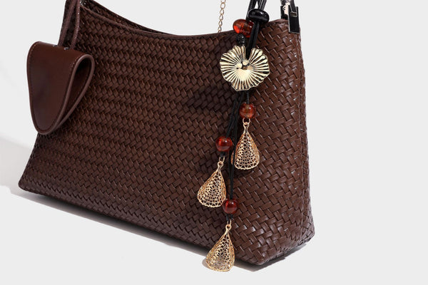 Woven-texture hobo shoulder bag in brown with braided top handle, adjustable crossbody strap, front flap pocket, and, detail