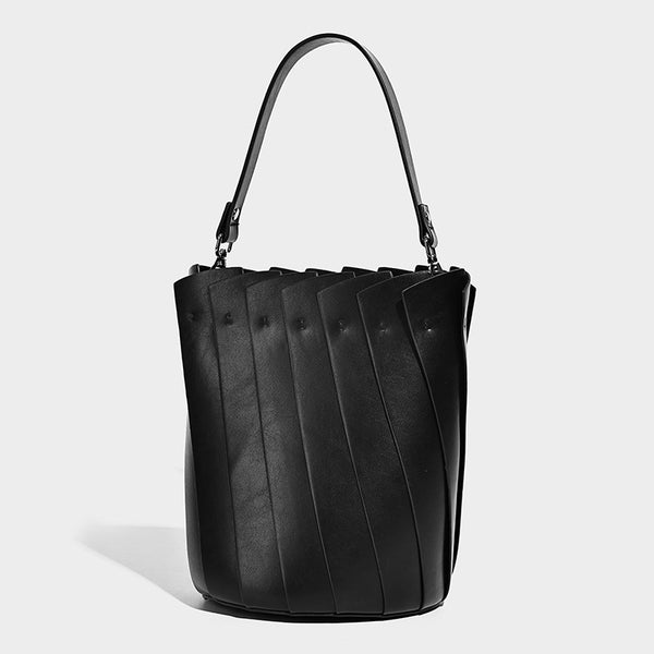 Structured pleated-panel bucket bag with curved top handle and detachable adjustable shoulder strap in smooth matte, detail
