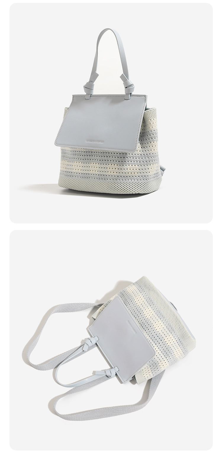 Small structured woven-body flap bag with smooth leather-look front panel, knotted top handle, and wide adjustable shoulder