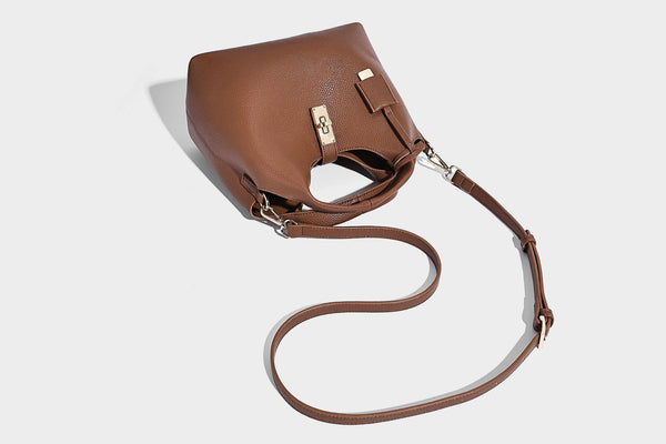 Structured pebbled-texture bucket bag with arched top handles, gold-tone turn-lock closure, and detachable shoulder strap