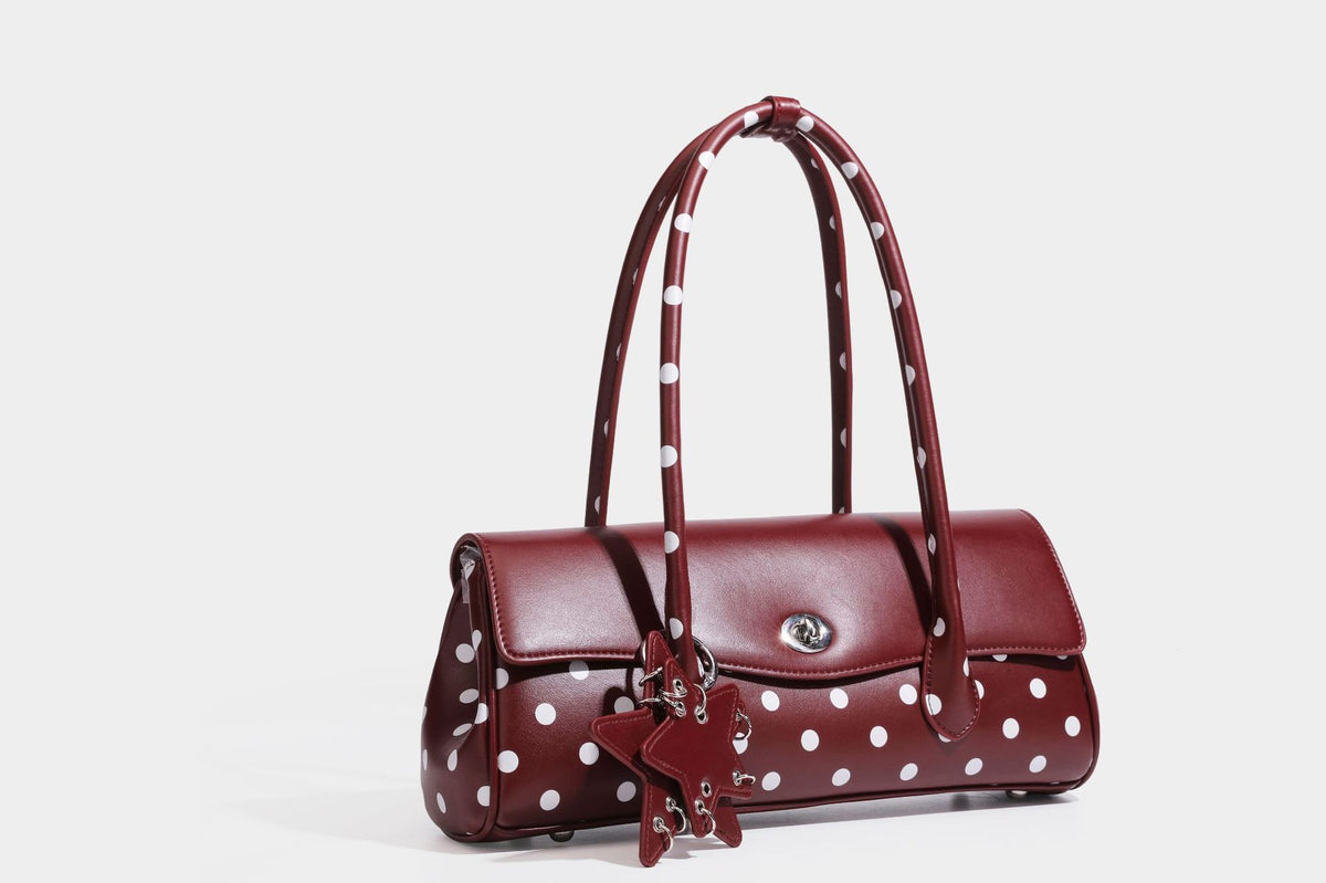 Strukturierte Baguette-Tasche mit Polka-Dot-Muster, glänzender Lederoptik, zwei Tragegriffen, silberfarbener Drehverschlussklappe und