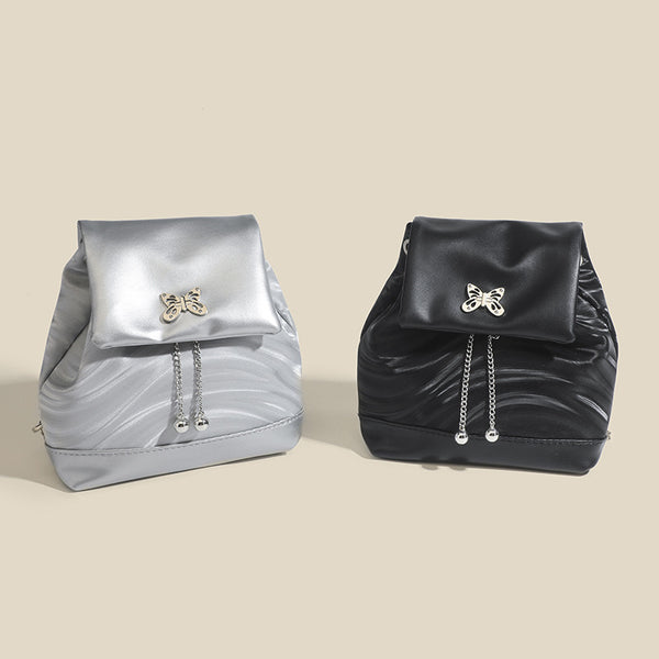 Compact ripple-embossed leather-look backpack handbag with silver butterfly clasp and chain straps, detail view 2