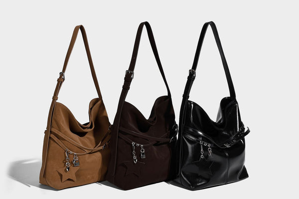 Große, weich fallende Schultertasche im Hobo-Stil aus matter Lederoptik mit Reißverschlussfach vorne und herabhängenden Stern- und Schlossanhängern in Silberoptik