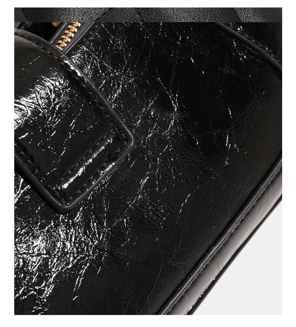 Structured glossy crinkled-finish shoulder bag with amber resin bead strap accent and gold-tone turn-lock closure, detail