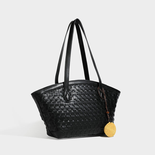 Large leather-look tote bag with geometric woven emboss, double shoulder straps, and round woven cord charm in brown, detail