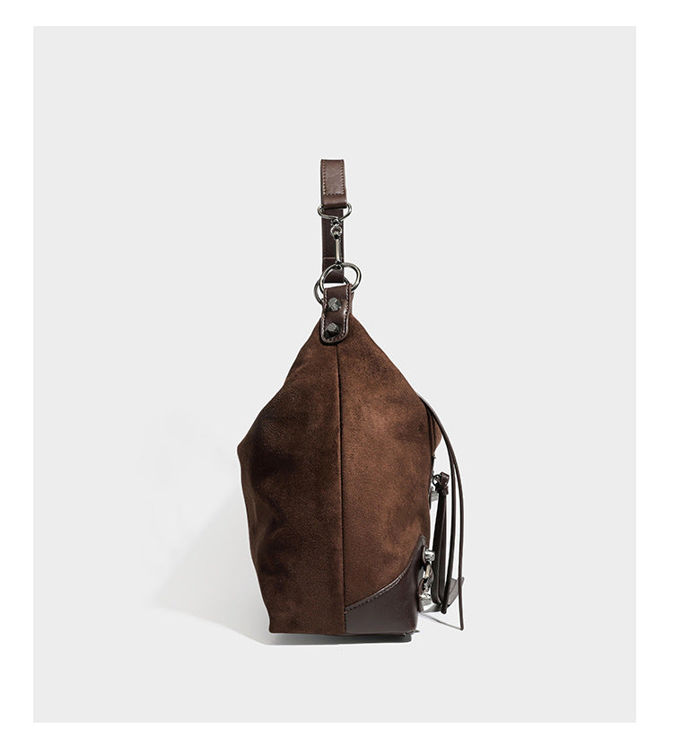 Slouchy suede-finish hobo shoulder bag with dark hardware, exterior zip pocket, tassel ties, and detachable crossbody strap