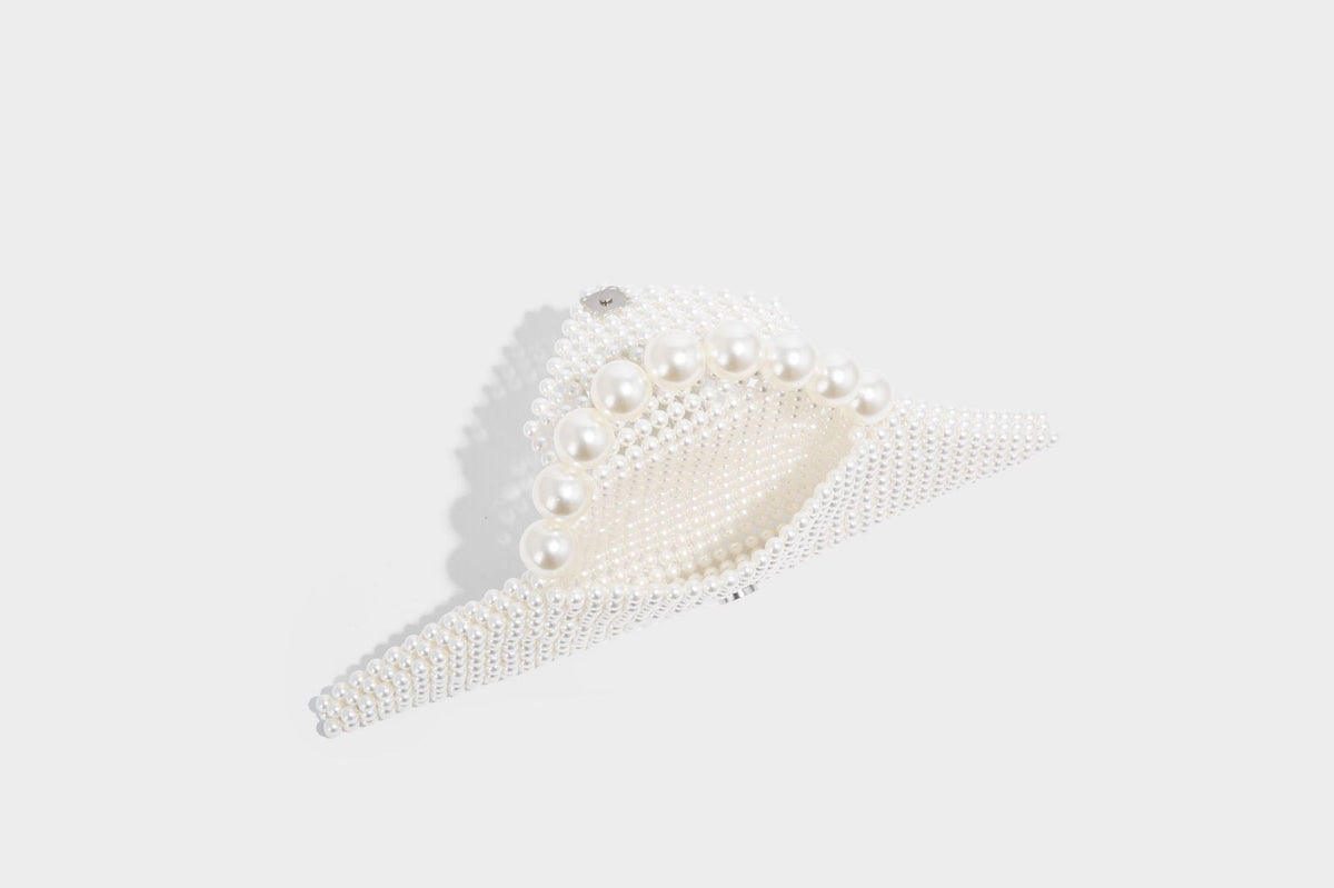 Small structured triangle clutch bag covered in glossy pearl beads with an arched pearl top handle and silver snap closure