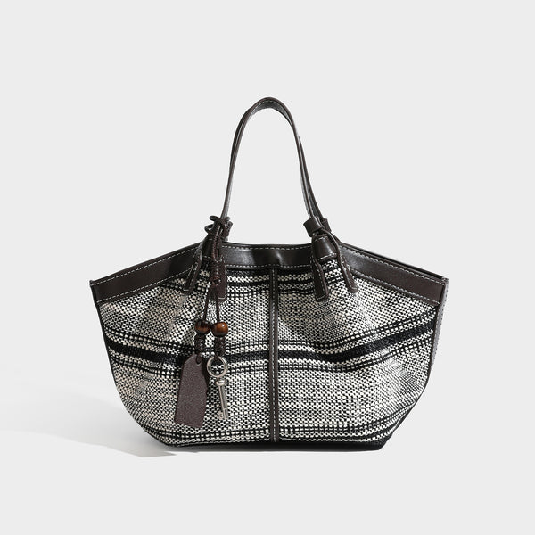 Schwarz-weiße gewebte Trapez-Tote-Bag mit dunkler Verzierung in Lederoptik, weißen Kontrastnähten und zwei Henkeln oben, Detail