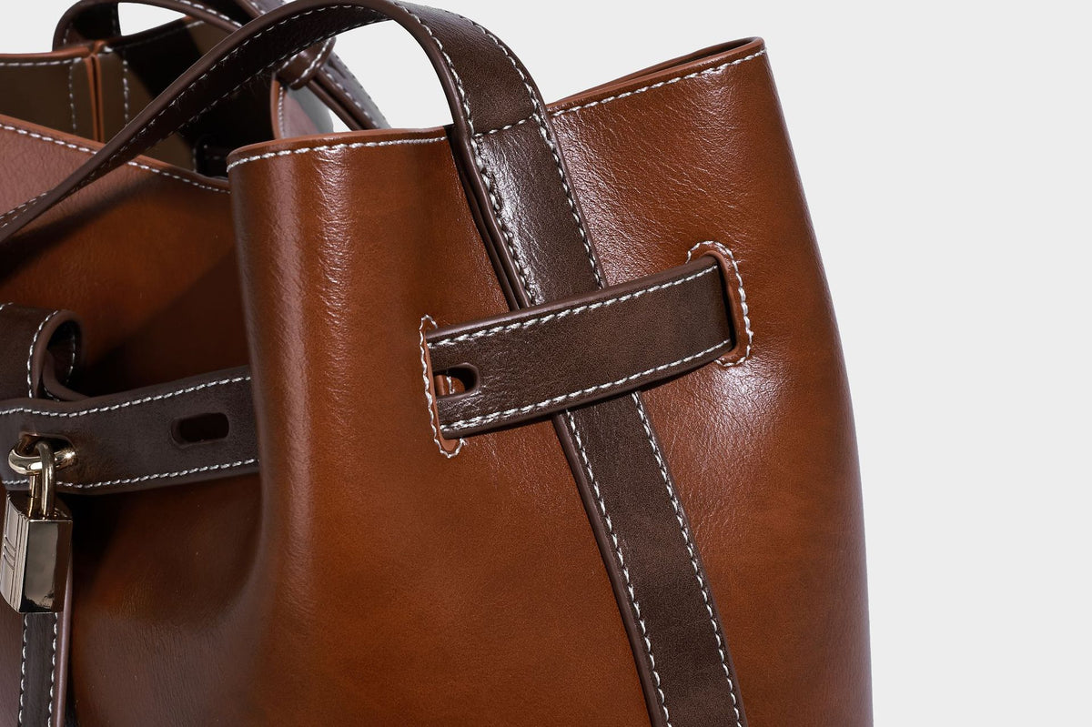 Glänzende Beuteltasche in Lederoptik mit Riemendetail mit Vorhängeschloss und verstellbarem langem Riemen, Detailansicht 22
