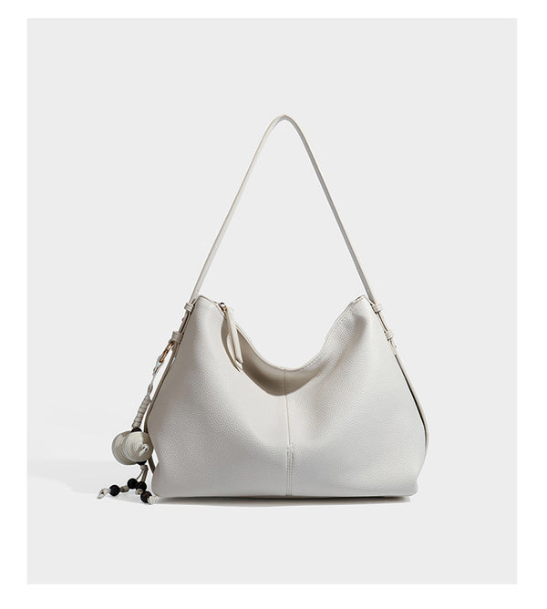 Slouchy hobo shoulder bag with pebbled leather-look finish, zip-top closure, gold-tone hardware, and hanging bead charm