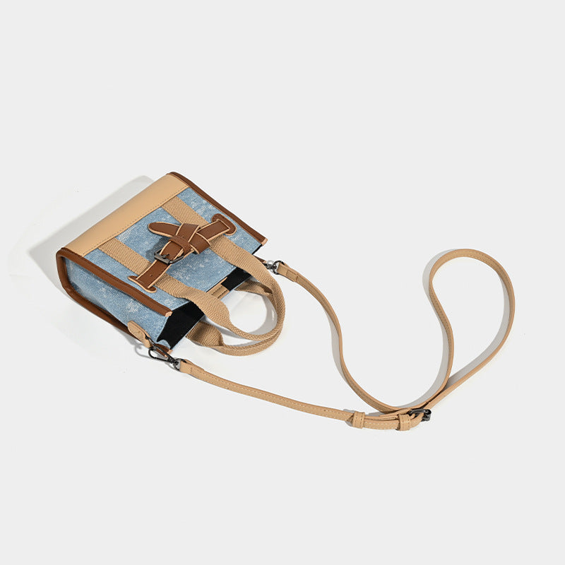 Structured mini tote bag in washed denim and neutral colorblock with brown leather-look trim and front belt buckle detail