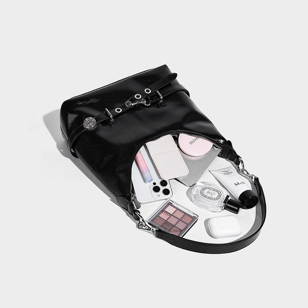 Glossy black slouchy hobo shoulder bag with silver-tone hardware, belt-style grommet strap at base, and long adjustable