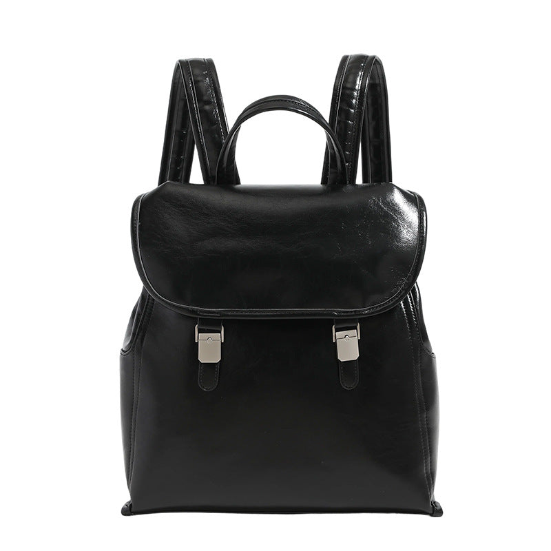 Structured glossy leather-look flap backpack with twin buckle closures and top grab handle, detail view 5