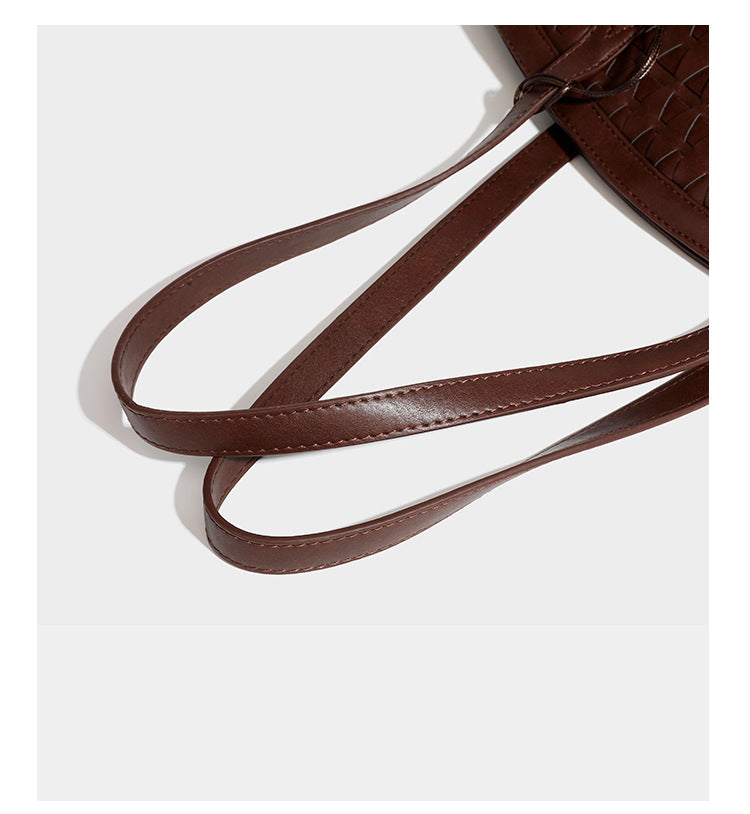 Large leather-look tote bag with geometric woven emboss, double shoulder straps, and round woven cord charm in brown, detail