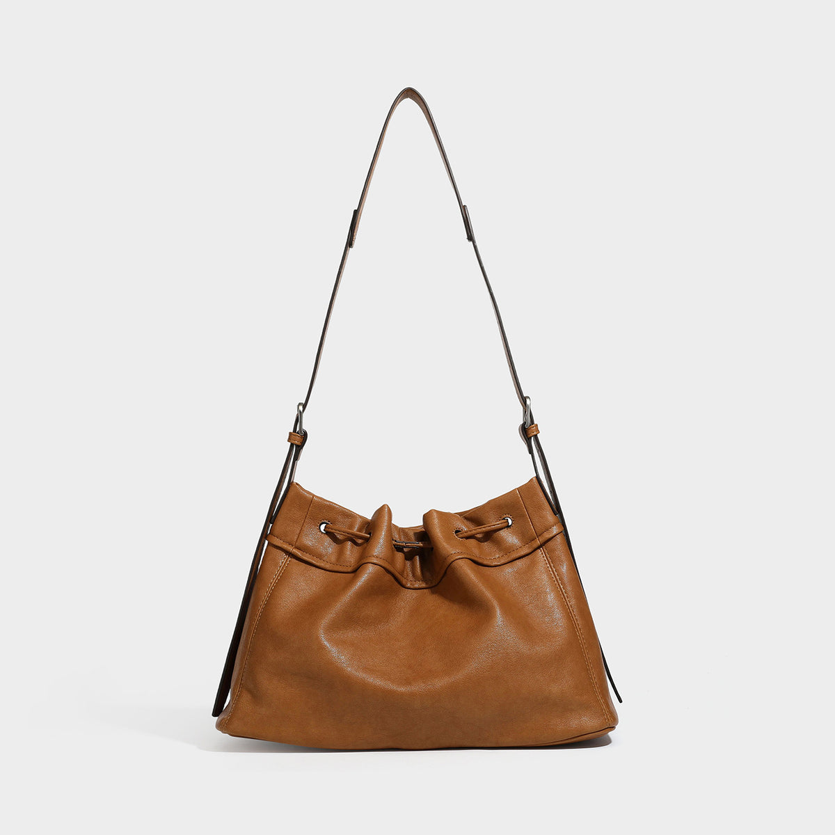 Slouchy drawstring bucket bag in dark brown leather-look finish with long adjustable shoulder strap and gathered tie closure