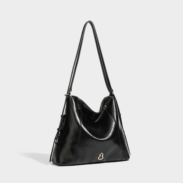 Große, lässig fallende Hobo-Schultertasche aus glänzendem Material in geknautschter Lederoptik mit goldfarbenen Beschlägen und langem verstellbarem Riemen